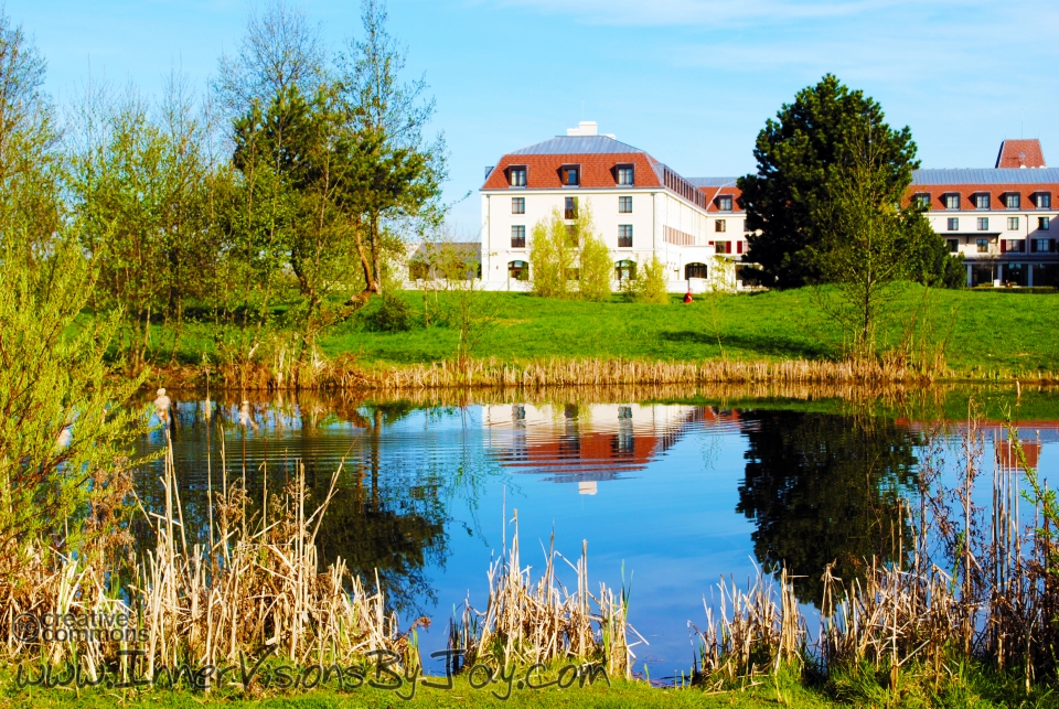 Red-roofed office reflected in a pond