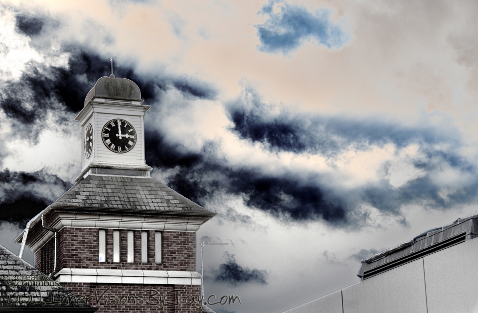 Churchyard clock against roiling clouds