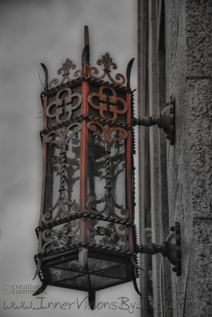 Black and white old-fashioned street lamp with red oozing from the top