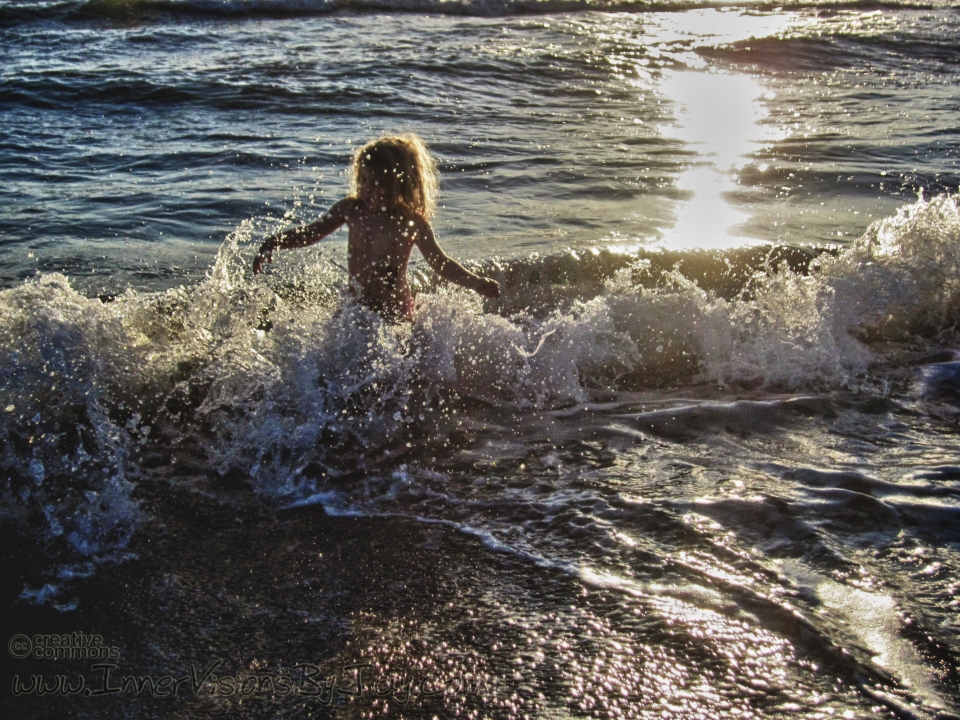 Girl frollicking in crashing ocean wave